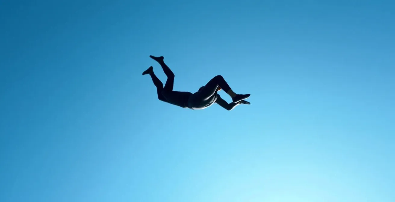 Vue latérale d'un parachutiste en position cambrée parfaite durant la chute libre